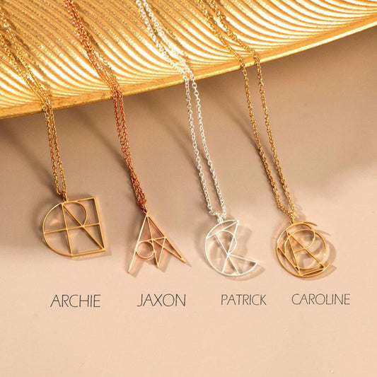 Four gold necklaces with different designs on a beige surface