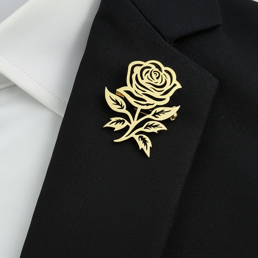 Gold rose brooch on a navy blue jacket with a white shirt background