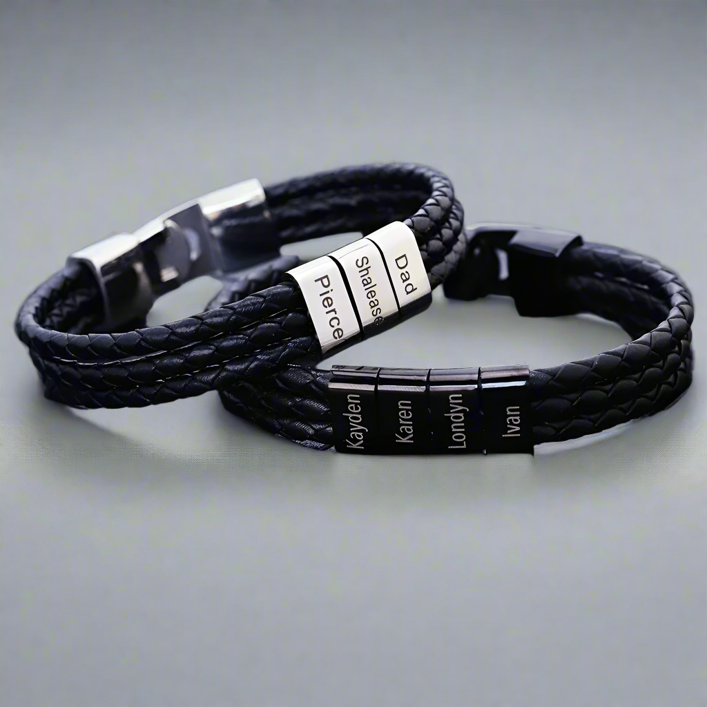 Black braided leather bracelets with metal tags on a grid background