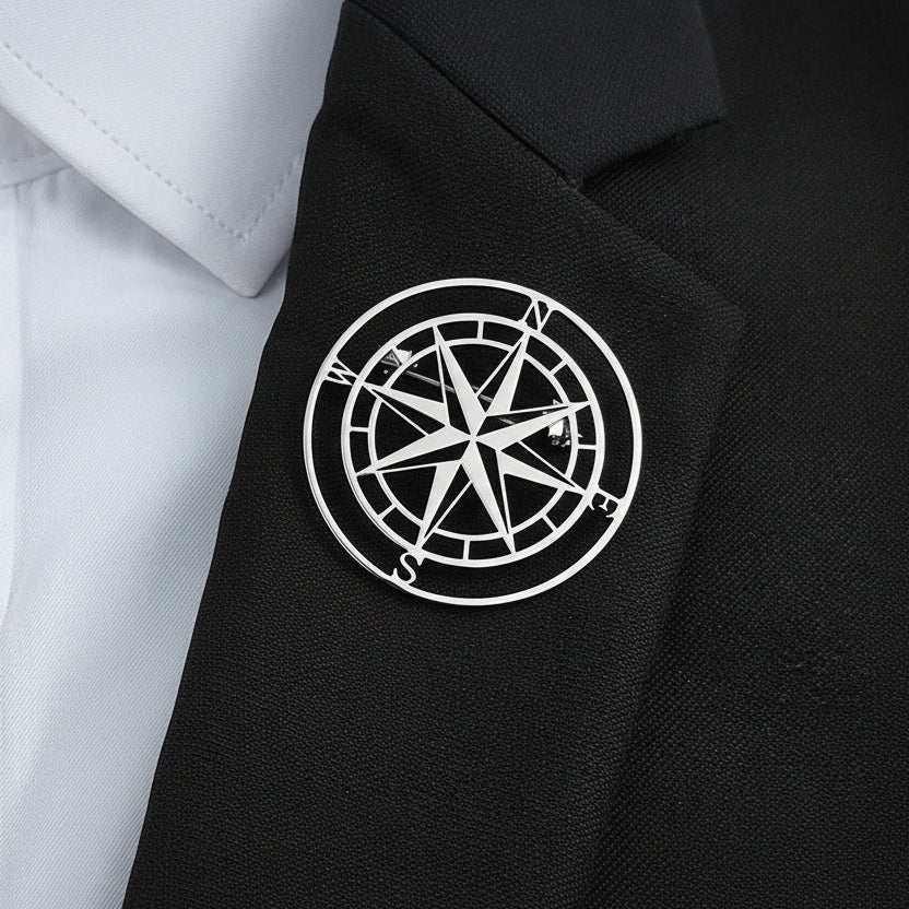 Navy blue jacket with a white compass rose emblem on a light blue shirt.