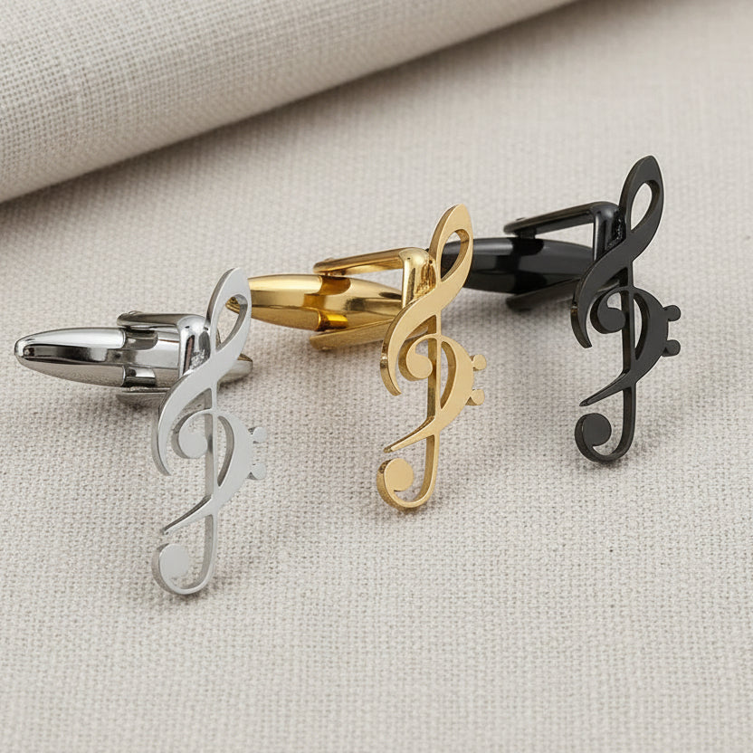 Three treble clef cufflinks in silver, gold, and black on a gray surface.
