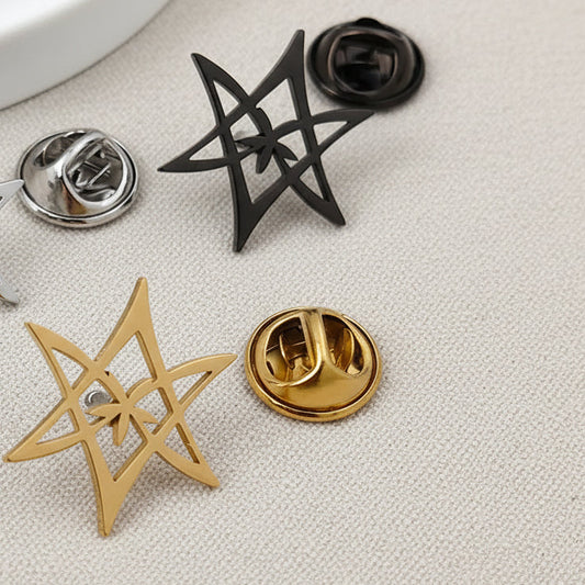 Star-shaped pins in silver, gold, and black on a light surface.