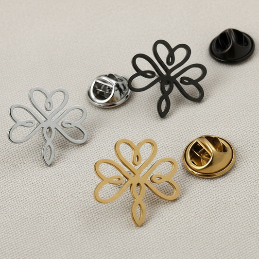 Set of metal flower-shaped pins in various colors on a textured surface