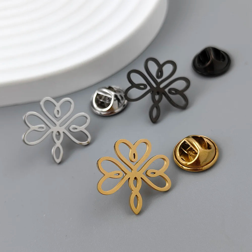A set of stainless steel brooches for men, displayed in silver, gold, and black colors, with a simple three-leaf pattern.
