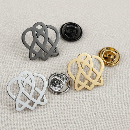 A selection of stainless steel brooches with a hollow love heart pattern, displayed in silver and gold colors.