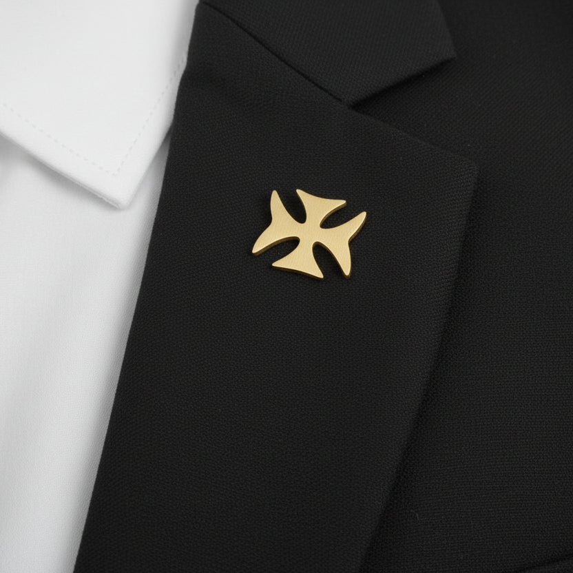 A collection of iron cross-shaped lapel pins in gold, silver, and black colors displayed on a white surface.