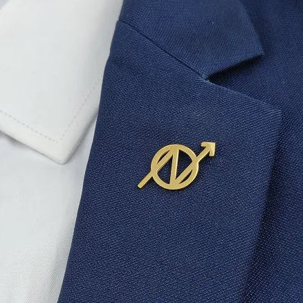 A collection of metal brooches in various colors including gold, silver, and black, featuring a geometric design.